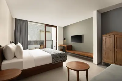 a hotel room with a bed and a tv at Dialoog Seminyak in Seminyak