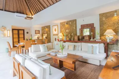 a living room with white couches and a table at Akhira One Seminyak in Seminyak