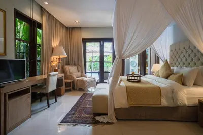 a bedroom with a bed and a desk and a television at Akhira One Seminyak in Seminyak