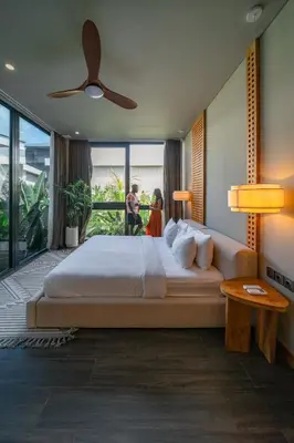 a bedroom with a large bed and a large window at Villa Amanora & Amaluna - 2 Stunning Villas, 9 Bedrooms for Groups in Canggu