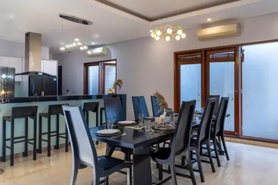 a dining room with a black table and chairs at Rumah Impian Villa by Betterplace in Canggu