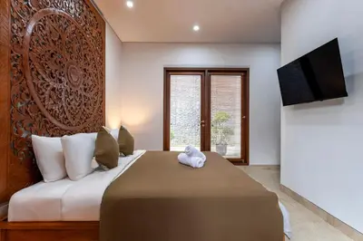 a bedroom with a large bed and a television at Rumah Impian Villa by Betterplace in Canggu