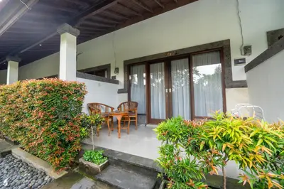 a house with a porch with a table and chairs at Ayu Guest House 2 in Canggu