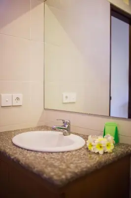 a bathroom counter with a sink and a mirror at Ayu Guest House 2 in Canggu