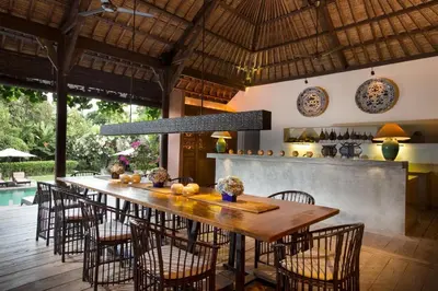 a dining room with a large wooden table and chairs at Villa Mamoune in Umalas