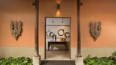 a room with a table and two mirrors on the wall at Villa Mamoune in Umalas