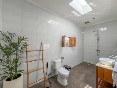 a bathroom with a toilet and a sink at Bubble Villa & Rice field view in Kerobokan