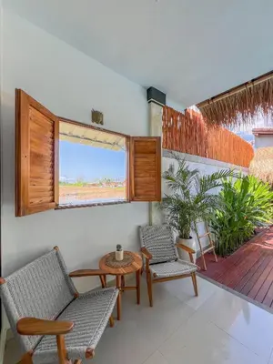 a room with chairs and a table and a patio at Bubble Villa & Rice field view in Kerobokan