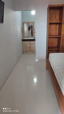 a bedroom with a bed and a bathroom with a sink at De Jaya in Kerobokan