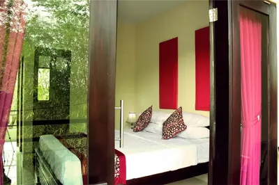 a bedroom with a bed with red and yellow walls at Ramantika Bali House in Jimbaran