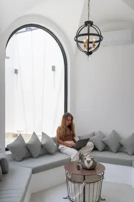 a woman sitting on a couch with a laptop at Villa Adela 1 Berawa 3BR Villa Near Atlas, Finns Beach Clubs in Canggu