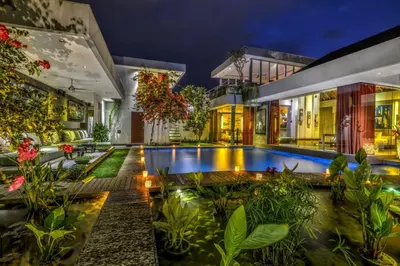 a villa with a swimming pool at night at Stunning 4 Bed, Butler Service, Security, Central in Seminyak
