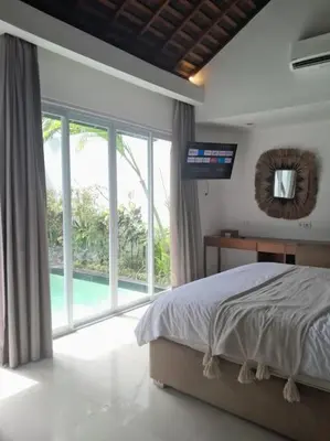 a bedroom with a bed and a large window at Rove One-bedroom Pool Villa Seminyak in Seminyak