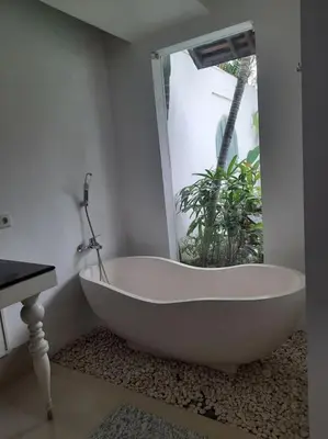 a white bath tub in a bathroom with a window at Rove One-bedroom Pool Villa Seminyak in Seminyak
