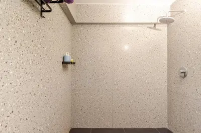 a bathroom with a shower stall with a bottle on a shelf at Sunset view apartment in Nusa Dua in Nusa Dua