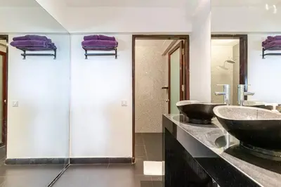 a bathroom with two sinks and purple towels at Sunset view apartment in Nusa Dua in Nusa Dua