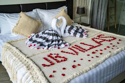 a bed with two swans and a sign that says happy anniversary at Villa Liamax by JB villas in Seminyak