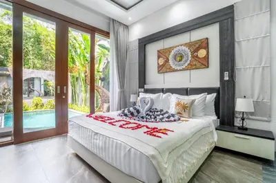 a bedroom with a large bed and a pool at Villa Liamax by JB villas in Seminyak