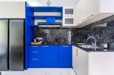 a blue kitchen with a sink and a refrigerator at Villa Ashëla by JB Villas in Seminyak