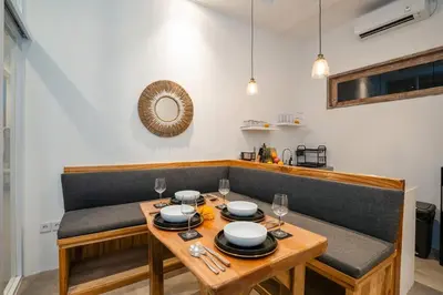 a table with plates and glasses on top of it at Vajrayana - 10 Min From The Beach, Serene Villa with Pool View in Kerobokan