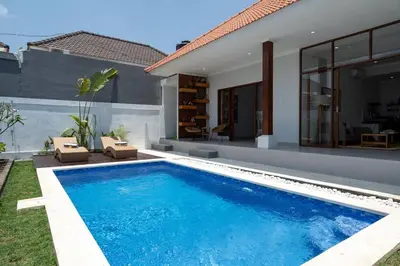 a swimming pool in front of a house at Umanala - 5 Min To Beach, Sleek Villa with Spacious Pool Area in Kerobokan