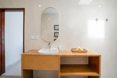 a bathroom with a sink and a mirror at Umanala - 5 Min To Beach, Sleek Villa with Spacious Pool Area in Kerobokan