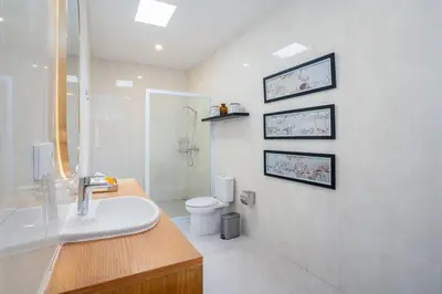 a white bathroom with a sink and a toilet at Umanala - 5 Min To Beach, Sleek Villa with Spacious Pool Area in Kerobokan
