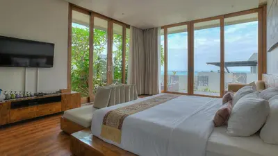a bedroom with a large bed with a large window at Villa Aiko in Jimbaran