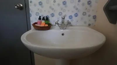 a bathroom sink with a basket on top of it at Poppies Cottages on Two in Legian