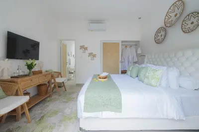 a bedroom with a large white bed and a desk at Casa Elias Seminyak in Seminyak