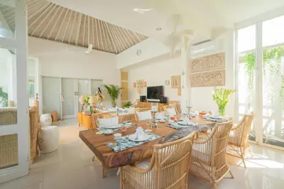 a dining room with a large wooden table and chairs at Casa Elias Seminyak in Seminyak