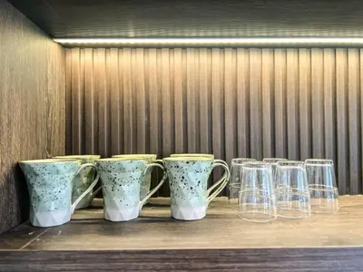 a row of cups and wine glasses on a table at Cara Villa Bali in Seminyak