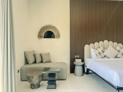 a bedroom with a bed and a couch and a table at Cara Villa Bali in Seminyak