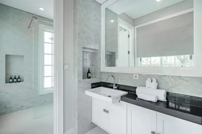 a white bathroom with a sink and a mirror at Viki Nest by SooBali 4BR in Umalas