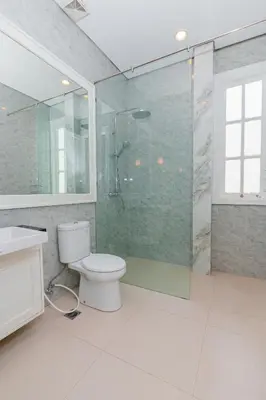 a bathroom with a toilet and a glass shower at Viki Nest by SooBali 4BR in Umalas