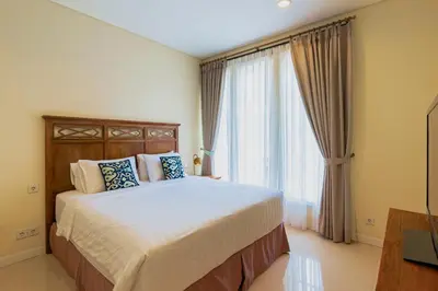 a bedroom with a bed and a large window at Viki Nest by SooBali 4BR in Umalas