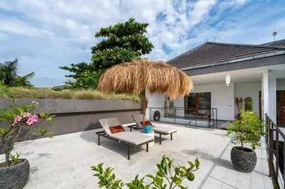 a patio with a couch and a chair at Beautiful modern villa in the heart of Seminyak in Seminyak