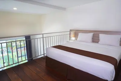 a bedroom with a large white bed and a window at The Salak Style Hotel in Denpasar