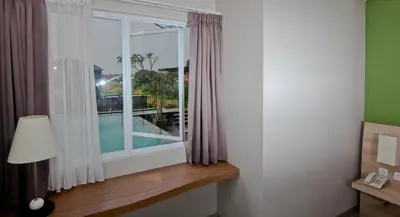 a room with a window with a view of a pool at The Salak Style Hotel in Denpasar