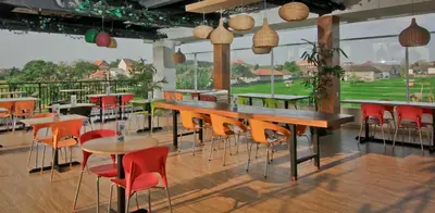 a restaurant with tables and chairs with a view at The Salak Style Hotel in Denpasar