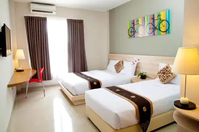 a hotel room with two beds and a window at The Salak Style Hotel in Denpasar