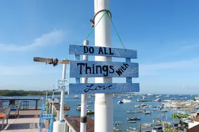 a sign that says do all things in love at Paras Paros Marina Lodge in Sanur