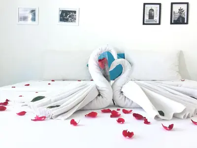 a bed with two swans made out of flowers at Paras Paros Marina Lodge in Sanur