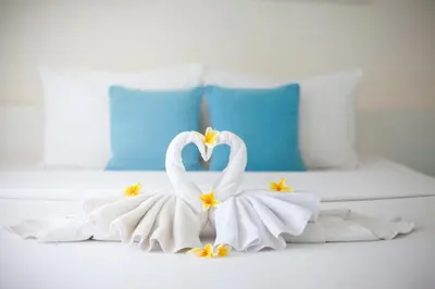 two swans made out of towels on a bed at Paras Paros Marina Lodge in Sanur