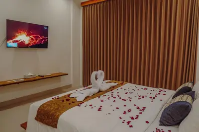 a bedroom with a bed with a towel animal on it at La Rylin Villa in Kuta