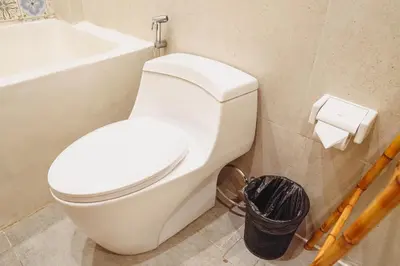 a bathroom with a white toilet and a bath tub at La Rylin Villa in Kuta