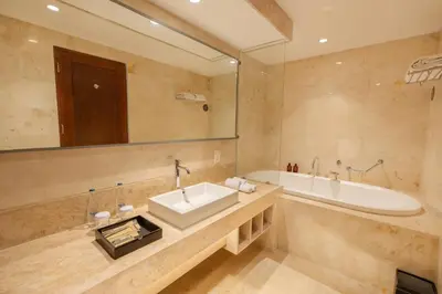 a bathroom with a sink and a bath tub at Kuta Angel Hotel in Kuta
