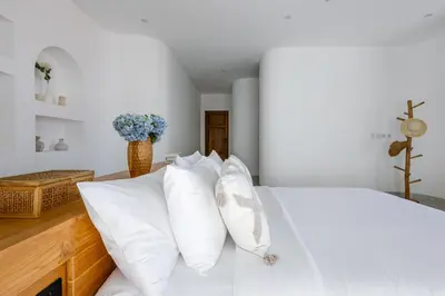 a bedroom with a white bed with white pillows at Villa Harper by BaliSuperHost in Canggu