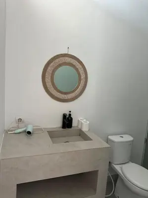 a bathroom with a toilet and a mirror on the wall at Villa with pool Nusa Dua in Nusa Dua