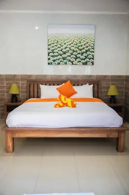 a bedroom with a bed with an orange bow on it at Lily Villa in Seminyak